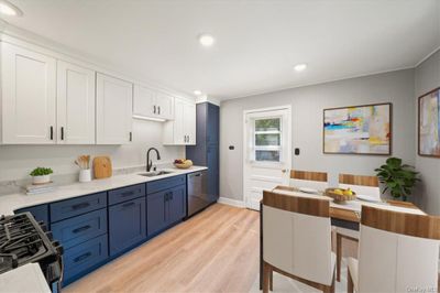 Kitchen with white cabinetry, light hardwood / wood-style flooring, sink, gas range, and stainless steel dishwasher | Image 3