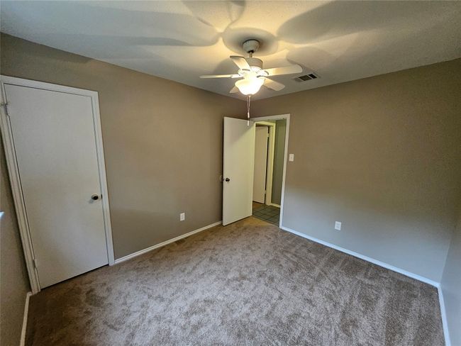 Unfurnished bedroom featuring carpet flooring, baseboards, a ceiling fan, and visible vents | Image 30
