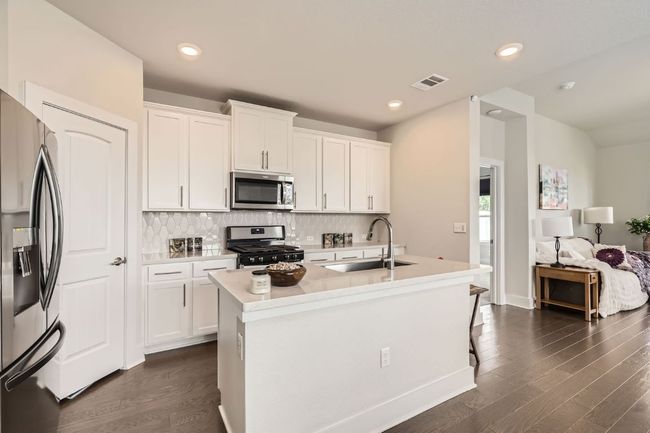 Kitchen with appliances with stainless steel finishes, tasteful backsplash, white cabinetry, dark wood-style flooring, and recessed lighting | Image 8