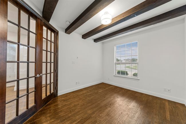 Unfurnished room with french doors, baseboards, wood finished floors, and beam ceiling | Image 5