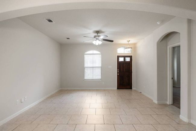 This thoughtfully designed home features an open and airy floorplan, high ceilings, and lots of windows that fill the space with natural light. | Image 7