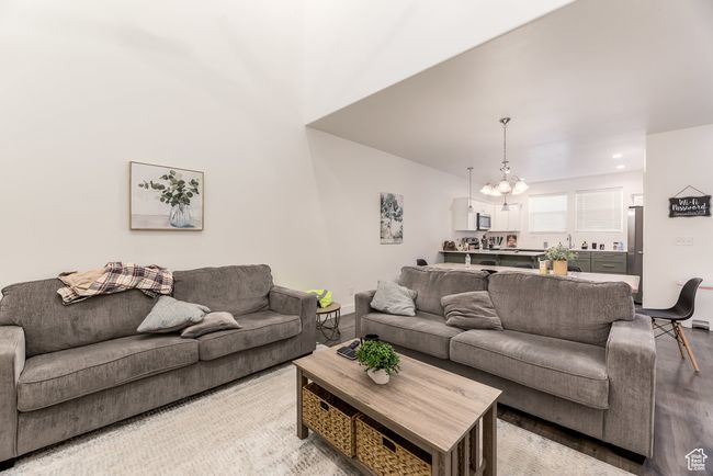 Living area with a chandelier and wood finished floors | Image 5
