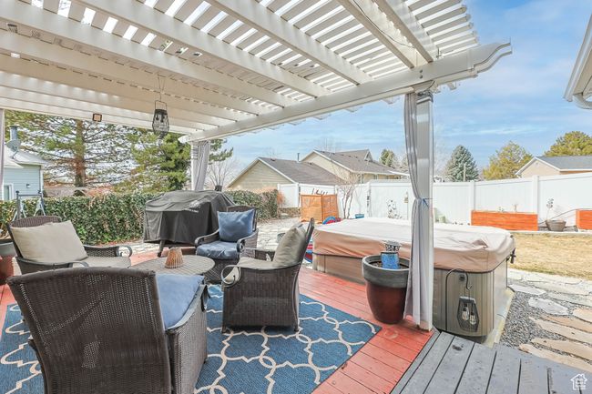 Deck with a hot tub, a pergola, grilling area, and a fenced backyard | Image 34