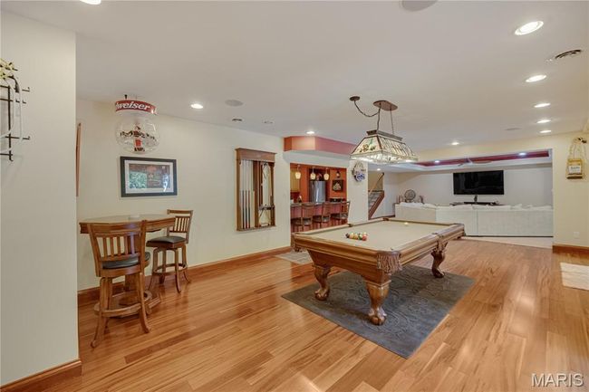 Playroom featuring light wood-style floors, pool table, recessed lighting, and bar | Image 51