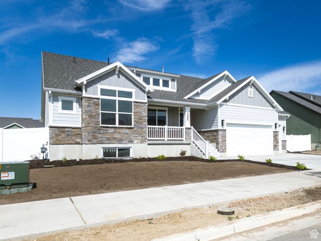 Craftsman house with stone siding, board and batten siding, an attached garage, and driveway | Image 4