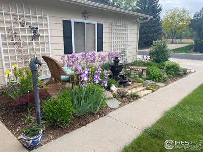 Garden sitting area beside garage with running fountain in spring bloom | Image 2