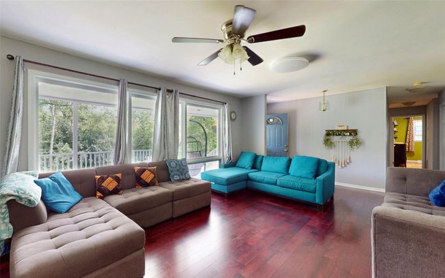 Living room with wood-type flooring, baseboards, and ceiling fan | Image 15