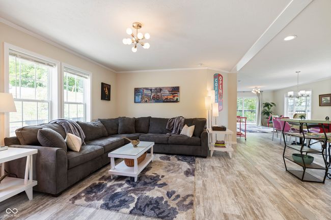 living area with a chandelier, wood finished floors, ornamental molding, and recessed lighting | Image 6
