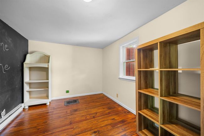 Empty room featuring a baseboard heating unit, hardwood / wood-style flooring, and baseboards | Image 11
