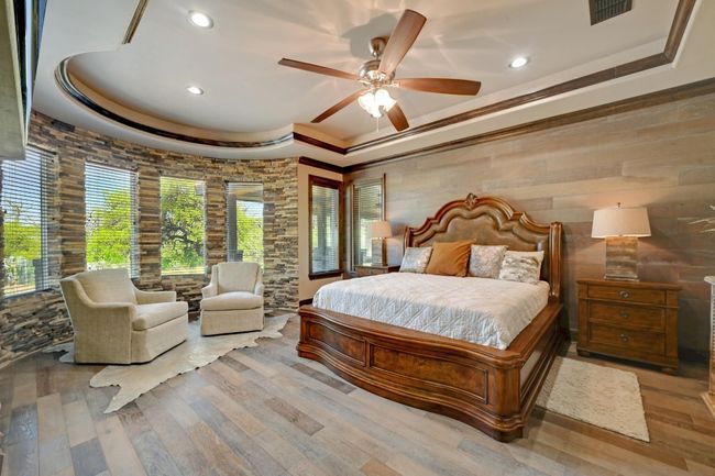 Bedroom with a raised ceiling, wood finished floors, visible vents, and recessed lighting | Image 21