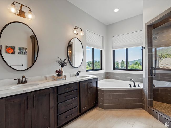Bathroom featuring a bath, healthy amount of natural light, and a stall shower | Image 27