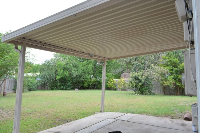 Fenced backyard with a patio | Image 11