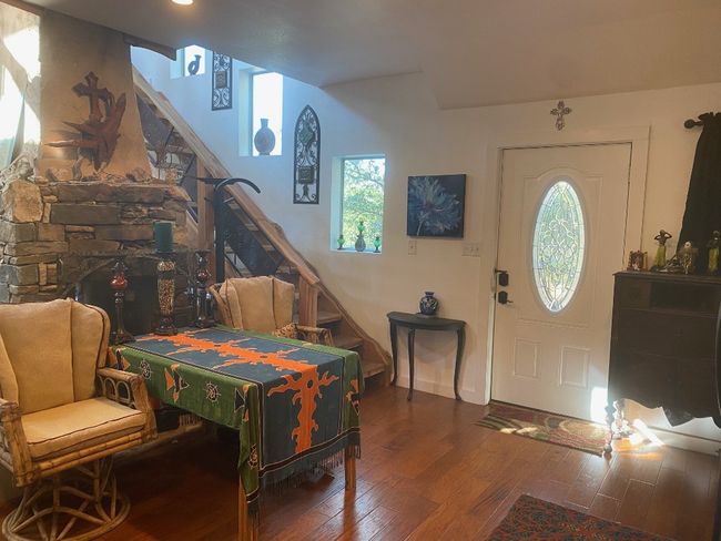 entry with 2 sided masonry fireplace and milled cedar staircase | Image 12