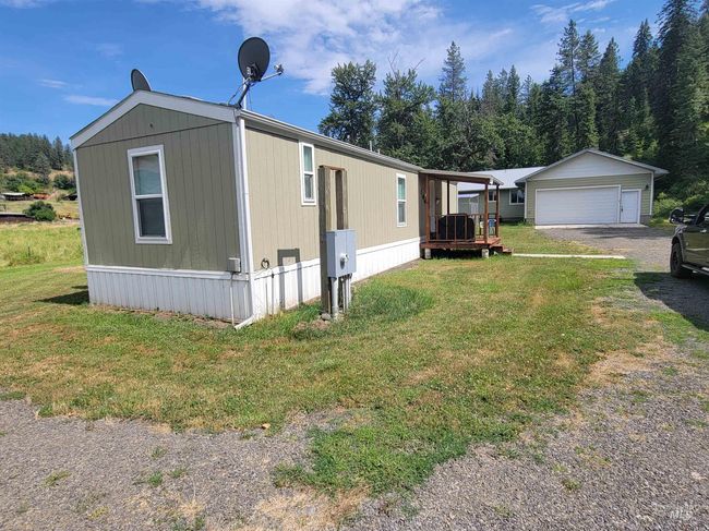 View of front of home featuring a garage, an outdoor structure, and a front lawn | Image 45