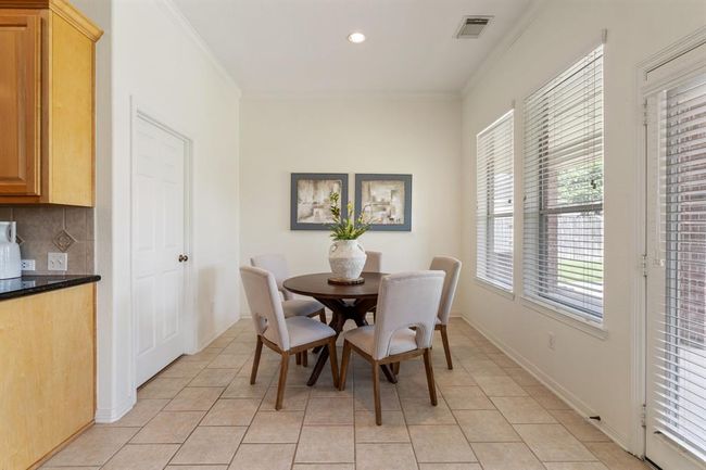 The breakfast nook is tucked just off the kitchen, featuring large windows that let in natural light and offer a clear view of the backyard. | Image 11