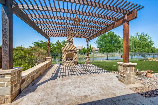 This versatile outdoor patio space, complete with a pergola and fireplace, can easily serve as an additional living area or a charming outdoor dining spot—perfect for year-round enjoyment. | Image 33