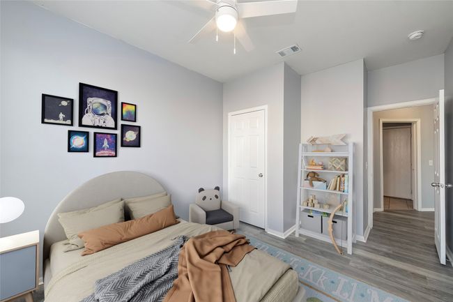 Bedroom featuring ceiling fan, wood finished floors, visible vents, and baseboards | Image 8