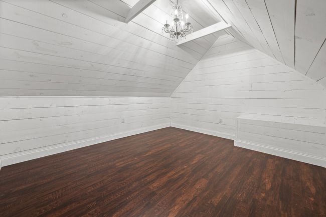 Additional living space with a chandelier, vaulted ceiling, wood ceiling, dark wood-type flooring, and wooden walls | Image 20