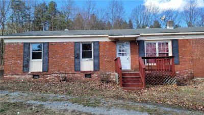 View of front of home with a wooden deck | Image 1