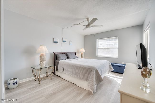 Bedroom with ceiling fan, a textured ceiling, and light wood-type flooring | Image 7