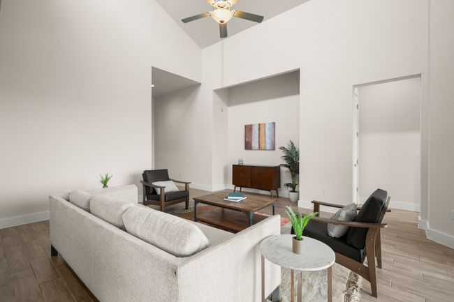 Living area featuring ceiling fan, high vaulted ceiling, and wood finished floors | Image 21