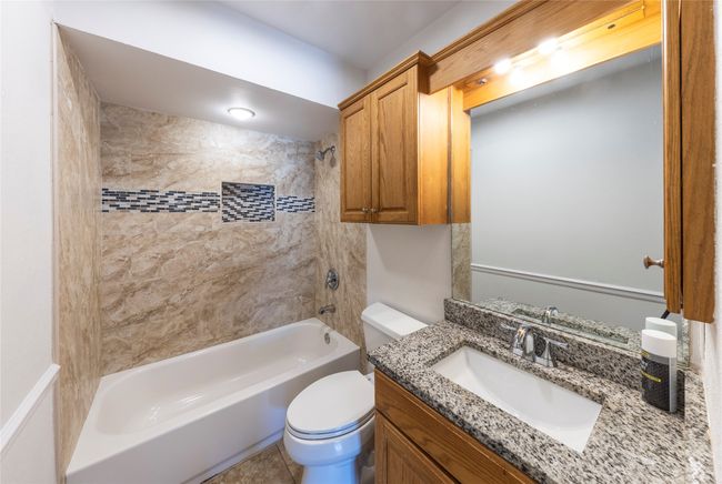 Hallway bathroom includes tiled bath/shower combo and granite vanity. | Image 16