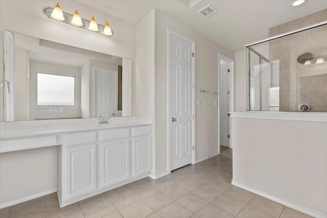 Full bath with a stall shower, vanity, light tile patterned flooring, and a closet | Image 12