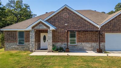 View of front facade featuring a front yard and a garage | Image 2