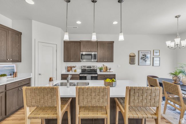 Kitchen featuring a kitchen breakfast bar, pendant lighting, and stainless steel appliances | Image 10