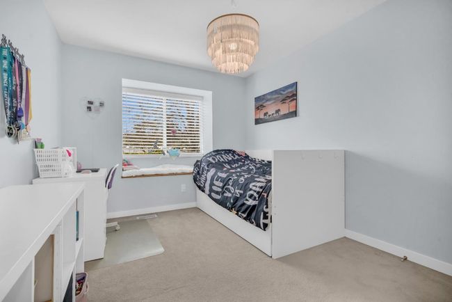 Carpeted bedroom featuring baseboards and a chandelier | Image 17