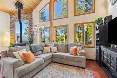 Living room w/ a gas stove, lofted ceiling, and open floor plan. | Image 3