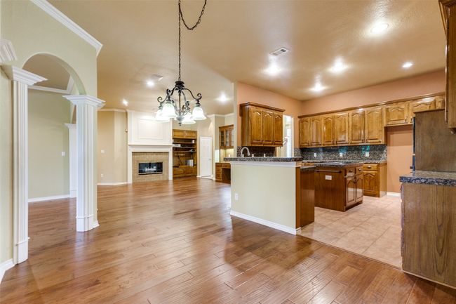 View of breakfast room looking into kitchen and den. | Image 8
