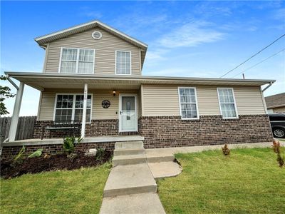 View of front property featuring a front lawn and a porch | Image 1