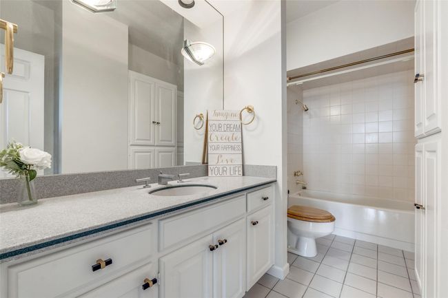 Bathroom featuring toilet, tile patterned floors, vanity, and bathtub / shower combination | Image 8