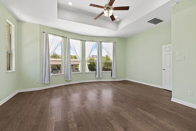 Spare room with a ceiling fan, dark wood-style flooring, a tray ceiling, and recessed lighting | Image 12