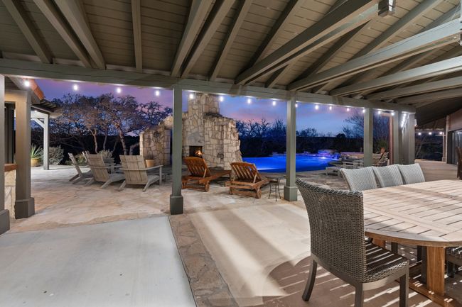 View of patio featuring outdoor dining space and an outdoor stone fireplace | Image 20