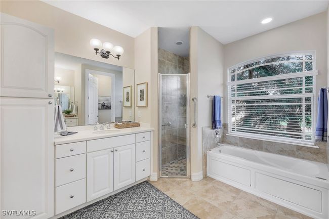 Bathroom with tile patterned flooring, a wealth of natural light, vanity, and shower with separate bathtub | Image 13
