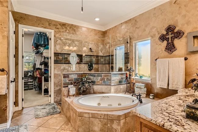 Full bath featuring tile patterned floors, plenty of natural light, crown molding, and a whirlpool tub | Image 21