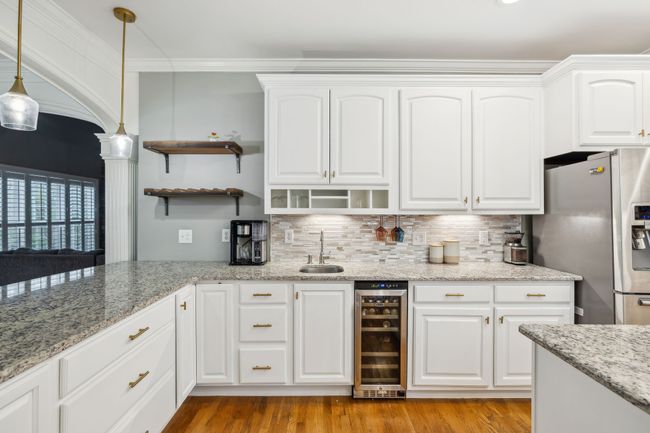 This kitchen even has a little mini bar with a wine refrigerator, wine rack, under cabinet stemware storage and a small sink. Perfect for entertaining! | Image 15
