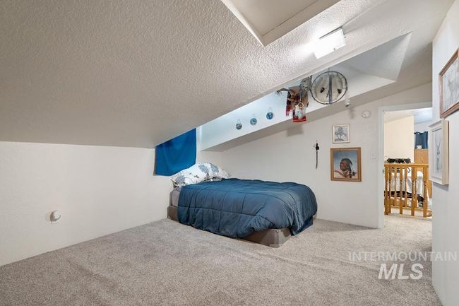 Carpeted bedroom with a textured ceiling | Image 28