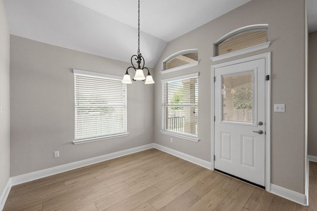 Foyer entrance with a chandelier, wood finished floors, and lofted ceiling | Image 11