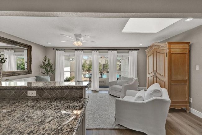 Living room with plenty of natural light, baseboards, light wood-style flooring, and ceiling fan | Image 10