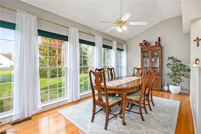 Dining area with light wood-type flooring, ceiling fan, and vaulted ceiling | Image 8