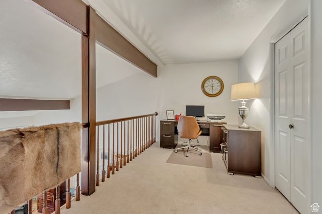 Office area with lofted ceiling with beams and light carpet | Image 18