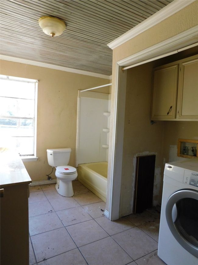 Washroom featuring crown molding, light tile patterned floors, and washer / dryer | Image 21