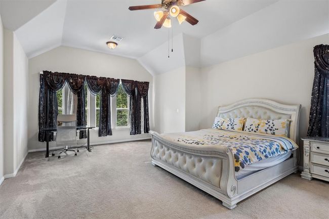 Carpeted bedroom featuring baseboards, vaulted ceiling, and a ceiling fan | Image 20