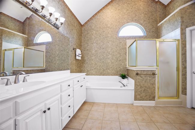 Full bath featuring plenty of natural light, a shower stall, vanity, tile patterned flooring, and wallpapered walls | Image 17