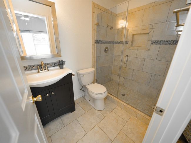 Bathroom with vanity, tile patterned flooring, a shower stall, and toilet | Image 18
