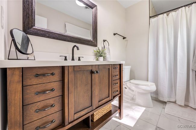 Full bathroom featuring a shower with shower curtain, toilet, vanity, and marble finish floor | Image 21