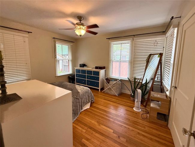 Bedroom with light wood-type flooring, multiple windows, and ceiling fan | Image 12